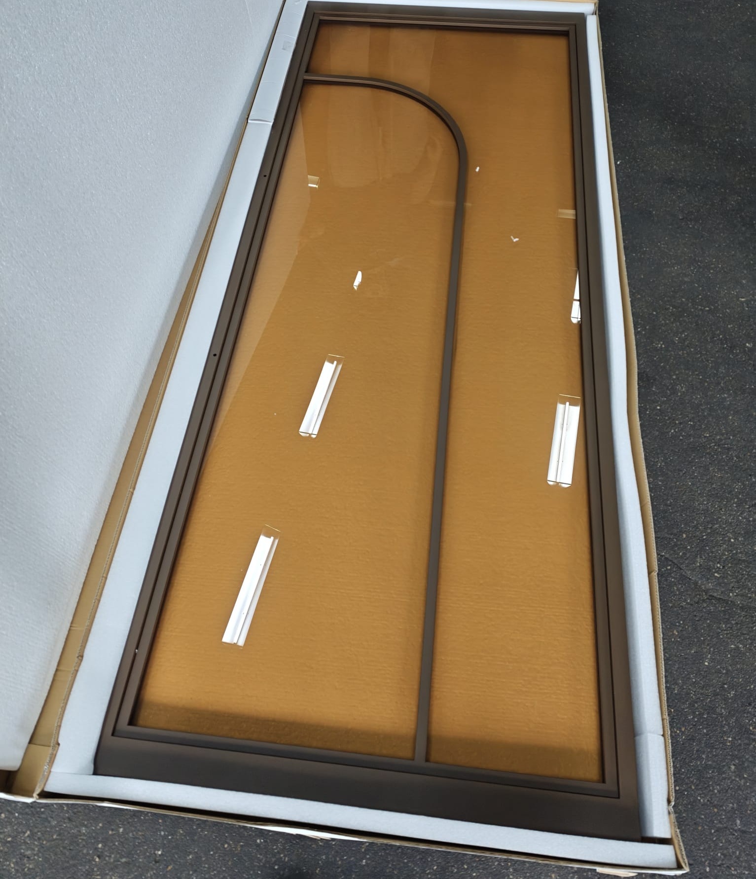 Bronzen taatsdeur met getint rookglas, ingepakt voor transport